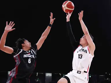 Pemain Timnas basket putra Indonesia (hitam) berusaha menghalau tembakan pemain Jepang, Ren Kanechika, dalam pertandingan Grup A Asian Games 2026 di Aichi International Arena, Nagoya, Jepang, Kamis (10/9/2026). Indonesia kalah 53-98 dari Jepang. (JIJI PRESS/AFP/Japan OUT)