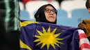 <p>Seorang suporter memegang bendera Malaysia jelang pertandingan sepak bola Grup E Piala Asia antara Malaysia dan Yordania di Stadion Al Janoub, Al Wakrah, Qatar, Senin (15/1/2024). (AP Photo/Aijaz Rahi)</p>
