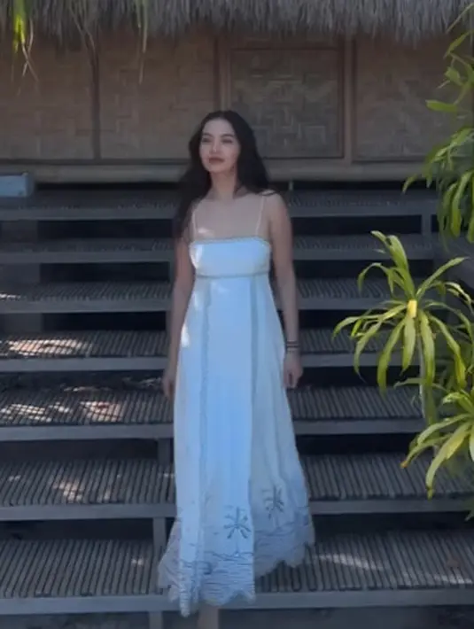 Raline Shah jelajahi Pantai Aili dengan gaya casual feminin mengenakan dress putih. Spagetti dress dengan cutout di bagian punggung dan detail lace yang cantik [@ralineshah]