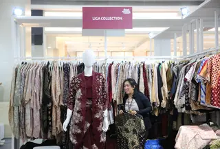 Tampil modis dengan gaya berwastra di masa kini. Bagian depan, sebuah manekin mengenakan setelan bernuansa merah marun dengan motif batik yang elegan, sementara di belakangnya deretan pakaian dengan beragam warna dan motif tertata rapi di gantungan. (Foto: Parade Wastra.doc)