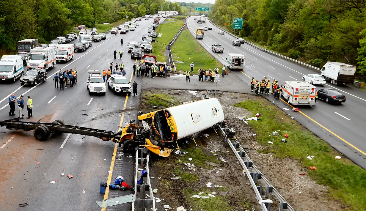 Personel darurat memeriksa kondisi bus sekolah yang bertabrakan dengan truk sampah di Interstate 80, Mount Olive, New Jersey, Kamis (17/5). Ada 45 orang berada di dalam bus, yakni tujuh orang dewasa dan 38 siswa. (Bob Karp/The Daily Record via AP)