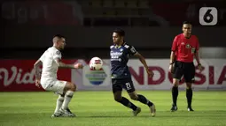 Pemain Persib Bandung Frets Butuan (tengah) mengontrol bola dibayangi pemain PS Sleman Aaron Michael Evans (kiri) dalam pertandingan semifinal leg kedua Piala Menpora 2021 di Stadion Manahan, Solo, Senin (19/4/2021). (Bola.com/Ikhwan Yanuar)