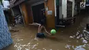 Anak-anak bermain saat banjir merendam permukiman di Kebon Pala, Jatinegara, Jakarta, Selasa (26/2/2019). Banjir setinggi 1,5 meter tersebut terjadi karena air Sungai Ciliwung meluap akibat air kiriman dari Bogor, Jawa Barat. (Merdeka.com/Imam Buhori)