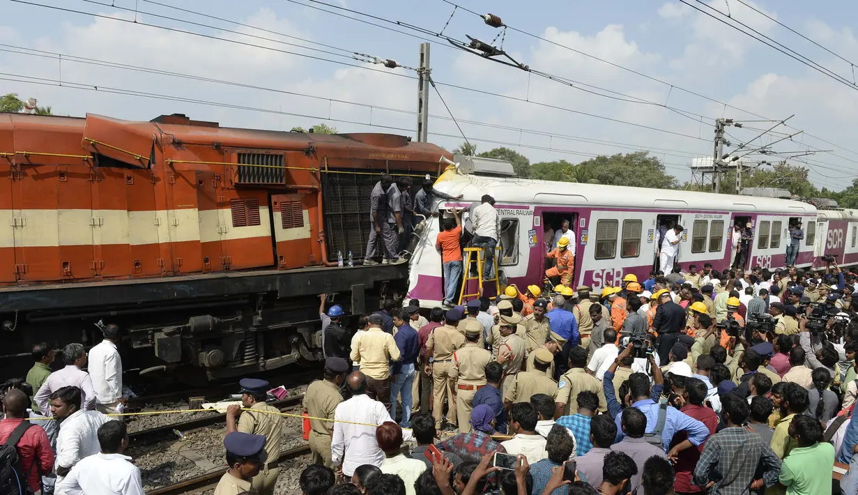 Petugas berusaha menyelematkan seorang pekerja di kabin kereta api surburban setelah bertabrakan dengan kereta ekspres antarkota di Stasiun Kereta Api Kachiguda di Hyderabad, India (11/9/2019). Sekitar 12 orang terluka akibat kecelakaan tersebut. (AFP Photo/Noah Seelam)