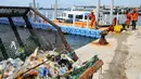 Petugas kebersihan UPK Pesisir dan Pantai membersihkan sampah di Dermaga Kali Adem, Jakarta, Kamis (14/4/2016). Kurangnya pemahaman warga tentang kebersihan lingkungan membuat Dermaga Kali Adem kerap dipenuhi sampah. (Liputan6.com/Yoppy Renato)