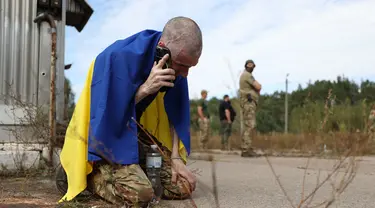 Seorang prajurit Ukraina menelepon setelah dibebaskan dari tawanan Rusia di sebuah lokasi yang dirahasiakan di dekat perbatasan Ukraina-Belarusia, pada 13 September 2024. (Anatolii STEPANOV/AFP)