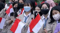 Siswa SMA sedang memegang bendera merah putih.