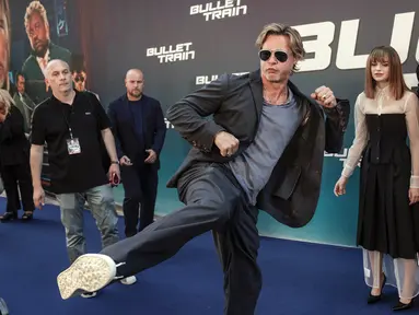 Brad Pitt bercanda dengan kameramen saat tiba pada pemutaran perdana film Bullet Train di Paris, Prancis, 18 Juli 2022. Brad Pitt menunjukkan penampilan energik saat dia menendang kakinya ke udara pada acara tersebut. (AP Photo/Lewis Joly)