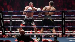 Petinju Rusia Sergey Kovalev (kiri) bertarung melawan petinju Inggris Anthony Yarde (kanan) selama pertarungan gelar juara kelas berat ringan WBO di Chelyabinsk, Rusia, Sabtu (24/8/2019). Kovalev merobohkan Yarde lewat KO di ronde 11. (AP Photo/Anton Basanayev)