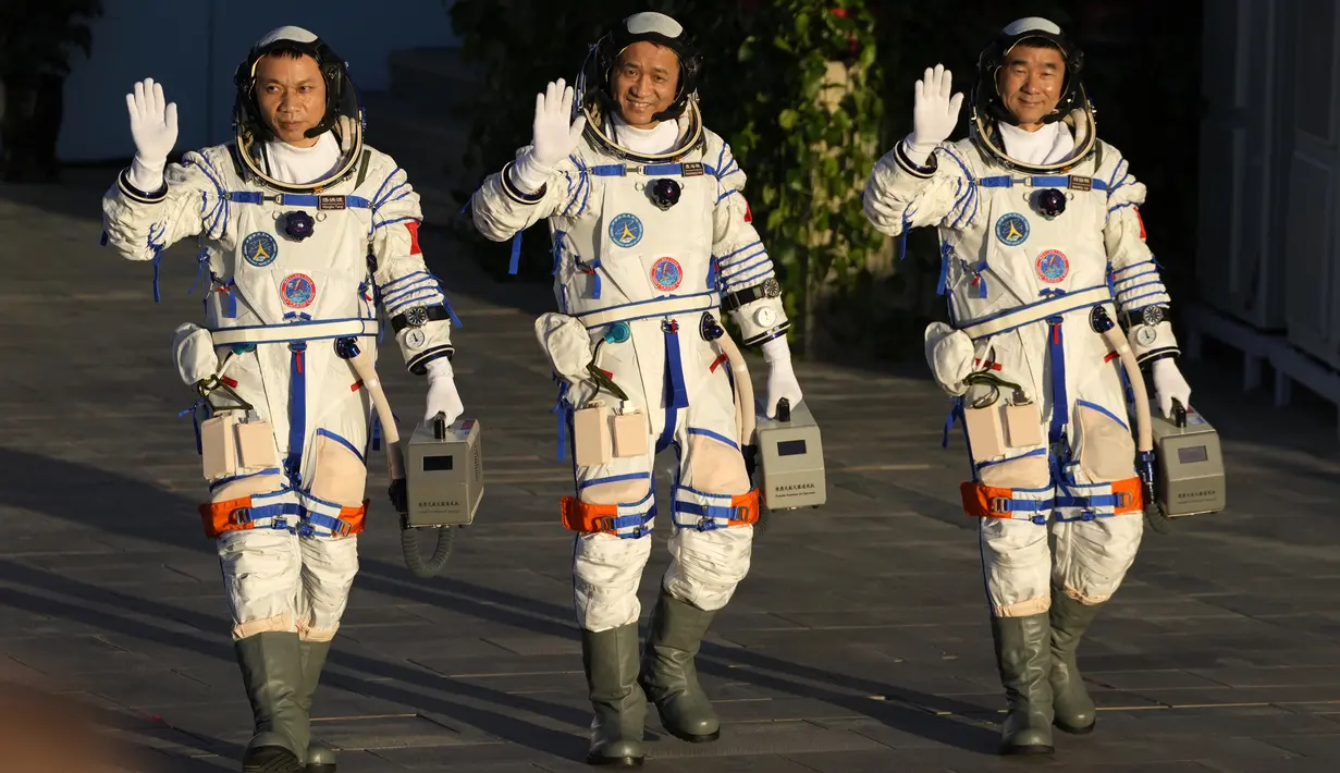 (kiri-kanan) Astronaut China Tang Hongbo, Nie Haisheng, dan Liu Boming melambai saat bersiap untuk lepas landas dari Pusat Peluncuran Satelit Jiuquan, China, Kamis (17/6/2021). Para astronaut menuju Tianhe, modul awal stasiun ruang angkasa Tiangong (Istana Surgawi) China. (AP Photo/Ng Han Guan)