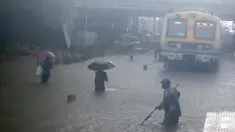 Warga melintasi rel kereta api yang terendam banjir saat hujan lebat di Mumbai, India, Rabu (9/6/2021). Mumbai terendam banjir usai diguyur hujan lebat. (AP Photo/Rafiq Maqbool)