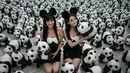 Para model berkostum hitam putih tampak berfoto dengan ribuan panda di Bandara Internasional Hong Kong, Senin (9/6/14). (AFP PHOTO/Philippe Lopez)