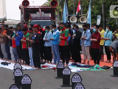 Sejumlah buruh menunaikan salat zuhur di sela aksi Hari Buruh Internasional atau May Day di Jakarta, Sabtu (1/5/2021). Sejumlah massa yang tergabung dalam serikat pekerja menggelar unjuk rasa di Hari Buruh ini. (Liputan6.com/Angga Yuniar)