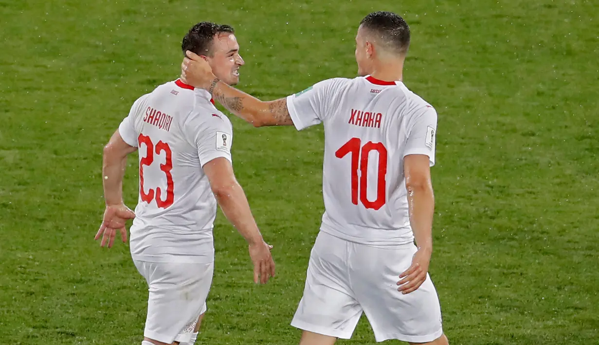 Pemain Swiss, Xherdan Shaqiri dan Granit Xhaka merayakan kemenangan atas Serbia pada laga grup E di Stadion Kaliningrad, Jumat (22/6). Keduanya sempat berselebrasi dengan gestur yang merujuk pengalaman kedua pemain atas negara Serbia. (AP/Antonio Calanni)