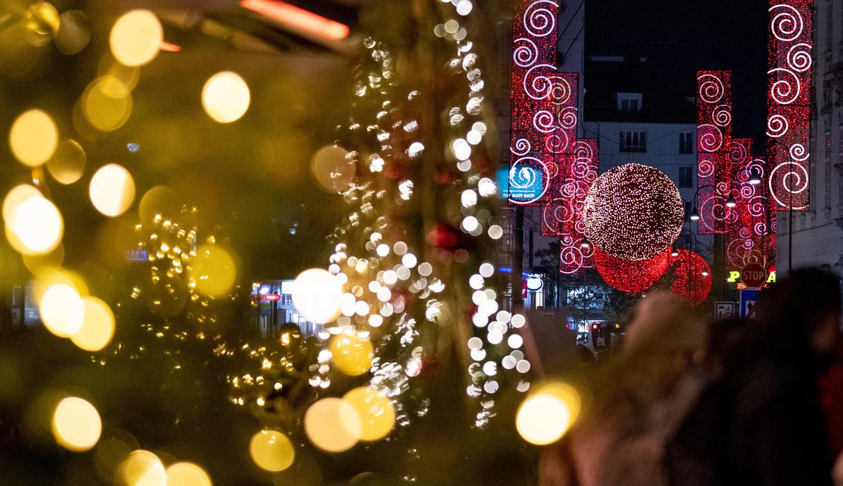 Orang-orang berjalan di sebuah jalan yang dihiasi dengan lampu-lampu Natal di pusat kota Wina, Austria pada 19 November 2024. (JOE KLAMAR/AFP)