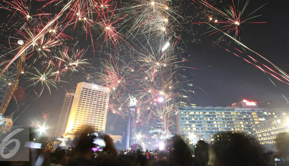 Kemeriahan kembang api menghiasi malam pergantian tahun di kawasan Bundaran HI, Jakarta, Sabtu (31/12). Antusiasme warga menyambut tahun 2017 diramaikan dengan pesta kembang api di sejumlah sudut Ibu Kota. (Liputan6.com/Immanuel Antonius)