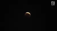 Foto fenomena gerhana bulan total di kota Jakarta, Sabtu (28/7). Gerhana bulan total "Micro Blood Moon" tersebut merupakan yang terlama pada abad ini dengan total waktu termasuk fase penumbra dan parsial selama enam jam lebih. (Liputan6.com/Johan Tallo)