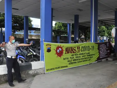 Petugas Direktorat Lalu Lintas Polda Jawa Tengah saat menggelar sterilisasi puluhan angkutan bus yang masuk di Terminal Bawen, Jumat (27/3/2020).  Sterilisasi dilakukan dengan menyemprotkan cairan disinfektan ke armada dan para penumpang yang turun di terminal tersebut. (Liputan6.com/Gholib)