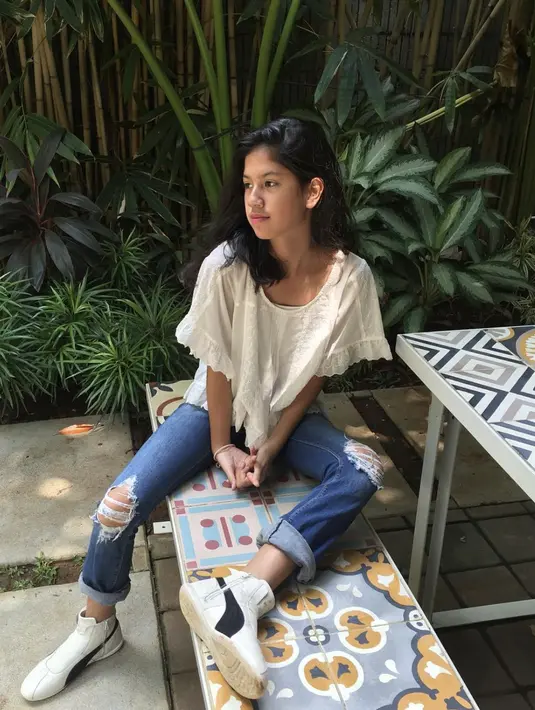 Ia juga menampilkan sentuhan boyis pada gayanya dengan pilihan denim dan sneakers.  [Instagram/Kyraawahab]