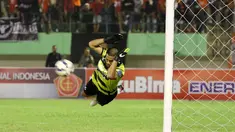 Kiper Persija, Andritany terbang menghalau bola pada laga Piala Jenderal Sudirman di Stadion Manahan, Solo, Selasa (15/12/2015). (Bola.com/Nicklas Hanoatubun)