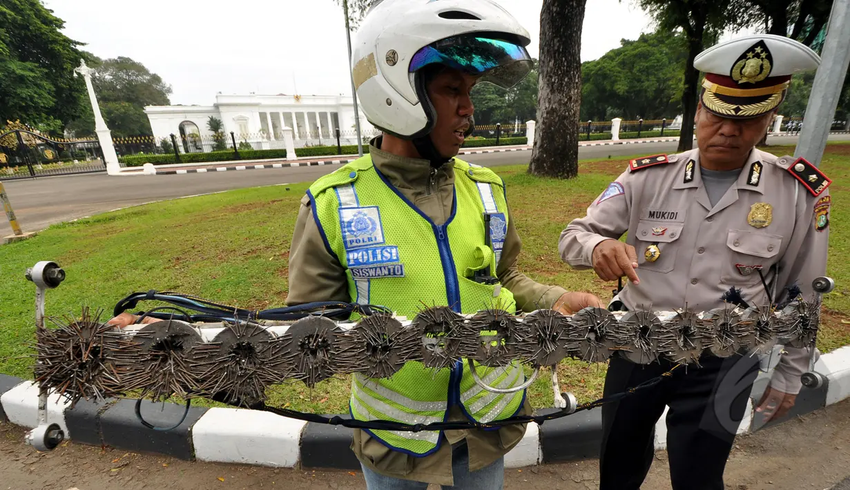 Seorang relawan dari SABER (Sapu Bersih Ranjau Paku) membersihkan ranjau paku di depan Istana Merdeka, Jakarta, Jumat (6/3/2015). Paku yang ditebar oleh orang tidak bertangung jawab seringkali mengganggu para pengguna jalan. (Liputan6.com/Faizal Fanani)