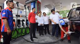 Presiden Joko Widodo (tengah) menyaksikan petugas mengisikan bahan bakar ke kendaraan saat meresmikan Implementasi Program Biodiesel 30 persen (B30) di SPBU MT Haryono, Jakarta, Senin (23/12/2019). Jokowi menargetkan implementasi program B40 pada 2020 dan B50 pada 2021. (Liputan6.com/Angga Yuniar)