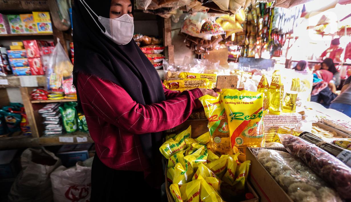 Pedagang menata minyak goreng kemasan di kiosnya Pasar Kebayoran Lama, Jakarta, Rabu (19/1/2022). Pemerintah resmi mengimplementasikan kebijakan minyak goreng satu harga Rp14.000 per liter untuk semua jenis kemasan mulai hari ini. (Liputan6.com/Johan Tallo)
