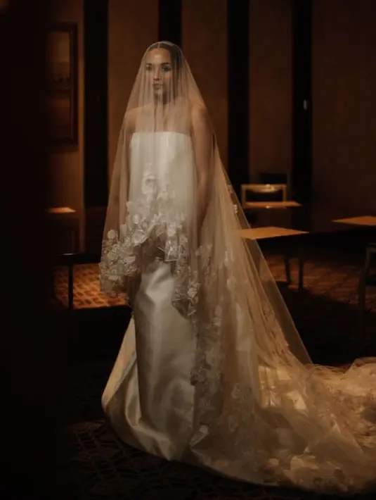 Angel Pieters memilih mengenakan gaun pernikahan putih off shoulder satin yang lengkap menggunakan veil panjang dengan detail bordiran dari Monica Ivena. [@angelpieters]