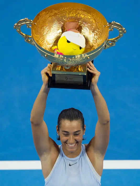 Petenis Prancis, Caroline Garcia mengangkat trofi yang diraihnya usai mengalahkan petenis nomor satu dunia Simona Halep pada final China Terbuka di Beijing, Minggu (8/10). Garcia, menjadi juara dengan mengalahkan Halep 6-4, 7-6. (NICOLAS ASFOURI/AFP)
