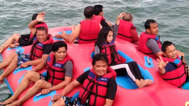 Beberapa pengunjung tengah menikmati fasilitas bermain di spot wisata air kawasan Pantai Timur Pangandaran, Jawa Barat.