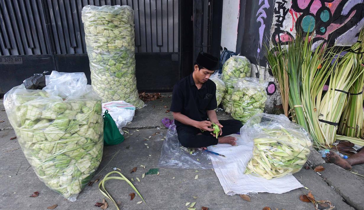 Kulit ketupat tersebut dipasarkan dengan harga Rp1.000 hingga Rp1.500 per buah, tergantung ukuran dan kualitas anyaman. Tampak dalam foto, pedagang menyelesaikan produksi kulit ketupat lebaran di Pasar Pondok Labu, Jakarta, Rabu (18/3/2026). (merdeka.com/Arie Basuki)