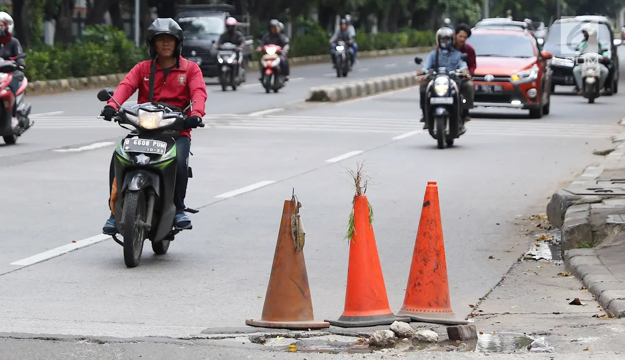 Pengendara menghindari jalan berlubang di kawasan Tanjung Barat, Jakarta, Rabu (30/1). Musim penghujan, pengguna jalan mengeluhkan jalan berlubang yang dipenuhi air. (Liputan6.com/Immanuel Antonius)