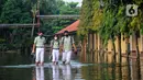 Siswa berjalan melewati banjir yang menggenangi halaman  sekolah di SMAN 4 Tangsel, Pondok Ranji, Tangerang Selatan, Banten, Selasa (14/6/2022). Tiga  pekan lebih banjir merendam lapangan sekolah itu dikarenakan tertutupnya saluran air oleh sampah yang berasal dari tempat pembuangan sampah (TPS) ilegal. (merdeka.com/Arie Basuki)