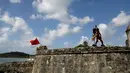 Seorang pria mengenakan kostum setan menari di dinding benteng San Jeronimo saat festival Congos and Devils di Portobelo, Panama (18/3). Festival ini digelar untuk melestarikan budaya dan menghormati nenek moyang mereka. (AP Photo/Arnulfo Franco)