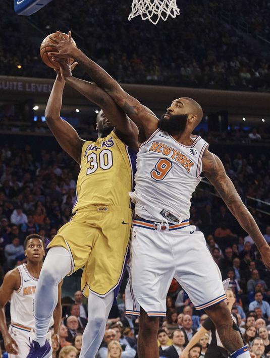 Pemain Los Angeles Lakers, Julius Randle (kiri) berusaha melewati adangan pemain New York Knicks, Kyle O'Quinn pada lanjutan NBA basketball game di Madison Square Garden, New York, (12/12/2017). knicks menang 113-109. (AP/Andres Kudacki)