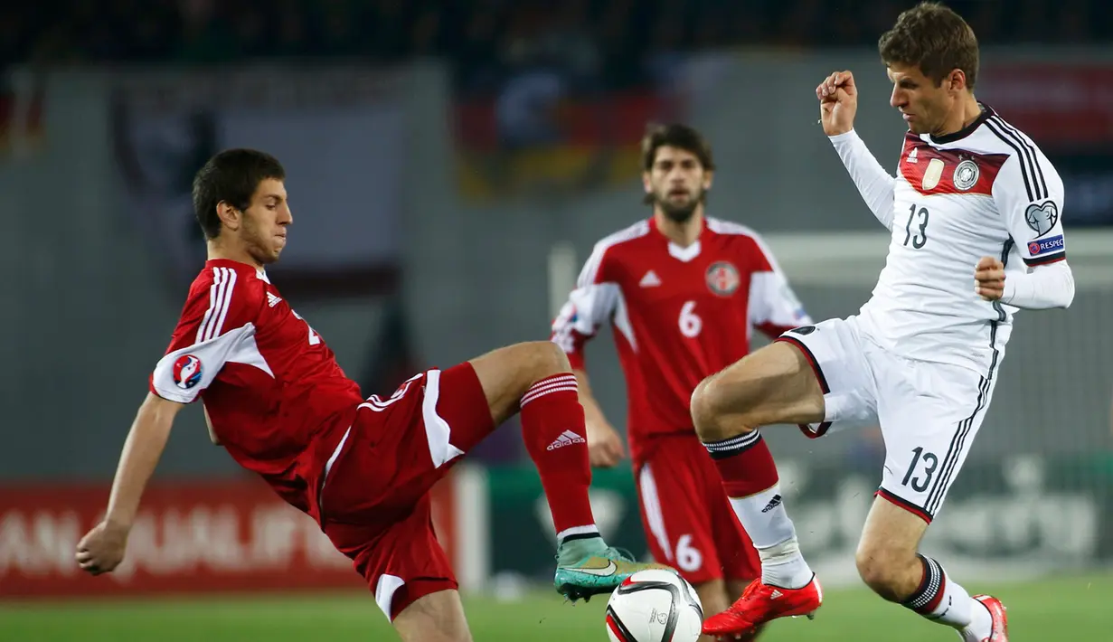 Bek Georgia, Lasha Dvali (kiri) berebut bola dengan pemain Jerman Thomas Mueller saat kualifikasi Piala Eropa 2016 di Locomotiv Stadium, Minggu (29/3/2015). Jerman menang 2-0 atas Georgia. (REUTERS/David Mdzinarishvili)
