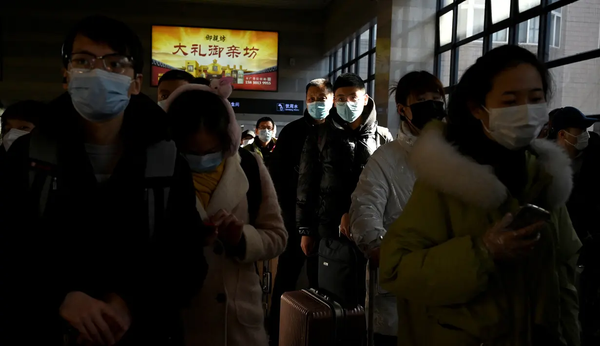 Sejumlah penumpang mengantre di stasiun kereta api Beijing Barat di Beijing, Kamis (27/1/2022). Tahun Baru Imlek 2022 yang jatuh pada 1 Februari mendatang akan jadi tahun shio macan. (AFP/Noel Celis)
