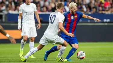 Penyerang Barcelona, Lionel Messi berusaha melewati gelandang Leicester City, Andy King di pertandingan International Champions Cup di Friends Arena, Stockholm, Swedia, (4/8). Barcelona menang atas Leicester dengan skor 4-2. (Reuters/Christine Olsson)