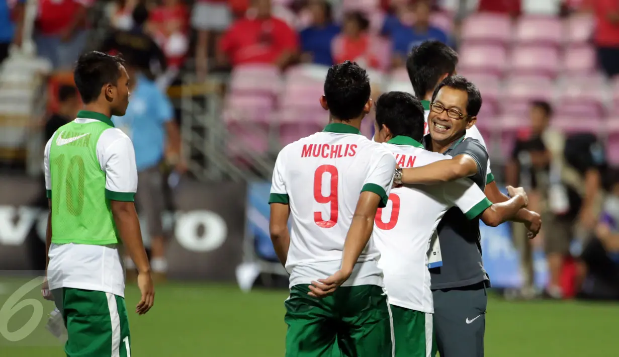 Pelatih timnas Indonesia U-23, Aji Santoso (kanan) memeluk Evan Dimas usai laga melawan Singapura di penyisihan Grup A SEA Games 2015 di Stadion Jalan Besar Singapura, Kamis (11/6/2015). Indonesia unggul 1-0. (Liputan6.com/Helmi Fithriansyah)