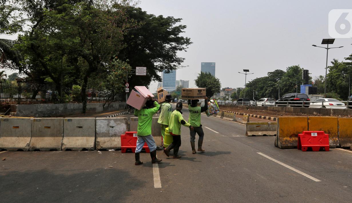 Petugas berjalan dekat road barrier beton yang dipasang di sekitar Gedung DPR RI, Jakarta, Kamis (17/10/2019). Direktorat Lalu Lintas Polda Metro Jaya kembali menutup sejumlah ruas jalan menuju kawasan Gedung DPR RI jelang pelantikan Presiden dan Wakil Presiden terpilih. (Liputan6.com/JohanTallo)