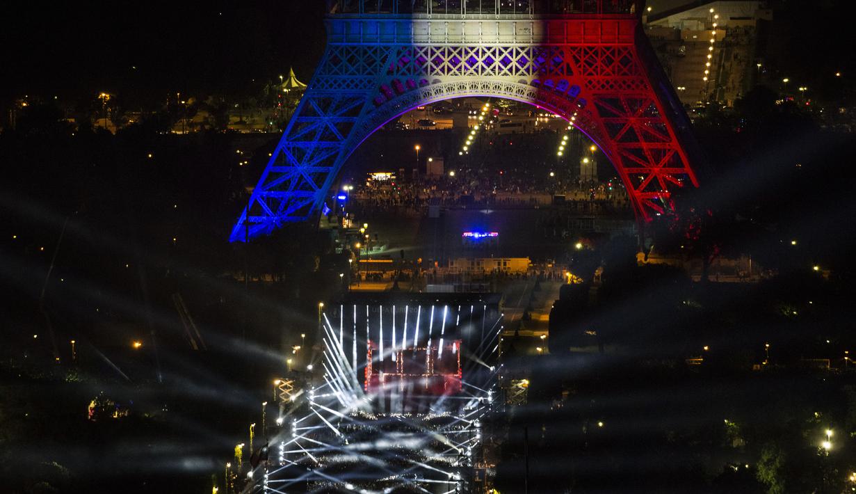 Suasana kemeriahan acara Champs de Mars yang digelar untuk menyambut Piala Eropa 2016 di Paris fan zone, belakang Menara Eiffel, Prancis, Jumat (10/6/2016). (AFP/Geoffroy Van Der Hasselt)