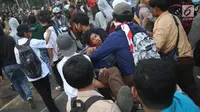 Sejumlah pelajar menggotong rekan mereka yang terluka dalam demonstrasi di belakang Gedung DPR, Palmerah, Jakarta, Rabu (25/9/2019). Pelajar bahu membahu membantu rekan mereka yang terluka dalam demonstrasi. (Liputan6.com/Angga Yuniar)
