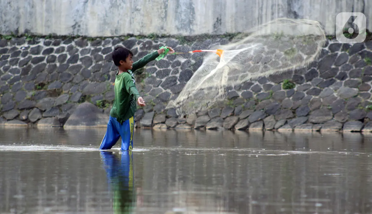 Seorang anak menjala ikan di area Bendung Katulampa, Kota Bogor, Jawa Barat, Senin (3/8/2020). Debit air sungai Ciliwung di Bendung Katulampa yang mengalami penyusutan sejak satu bulan terakhir dimanfaatkan anak-anak untuk bermain air dan layangan. (Liputan6.com/Helmi Fithriansyah)