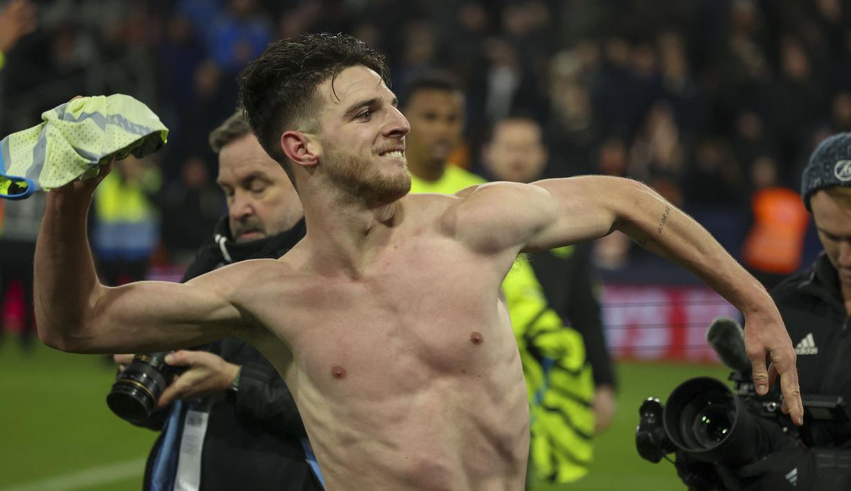 Gelandang Arsenal, Declan Rice membuka kaosnya untuk dilemparkan kepada fans dalam perayaan kemenangan atas Luton Town setelah berakhirnya laga lanjutan pekan ke-15 Liga Inggris 2023/2024 di Kenilworth Road, Luton, Rabu (6/12/2023) dini hari WIB. (AP Photo/Ian Walton)