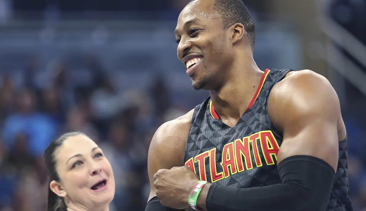 Pemain Atlanta Hawks, Dwight Howard tertawa bersama game official, Lauren Holtkamp (kiri) saat melawan Orlando Magic pada laga NBA basketball game di Amway Center, (4/1/2017). Atlanta menang 111-92. (Stephen M. Dowell/Orlando Sentinel via AP)