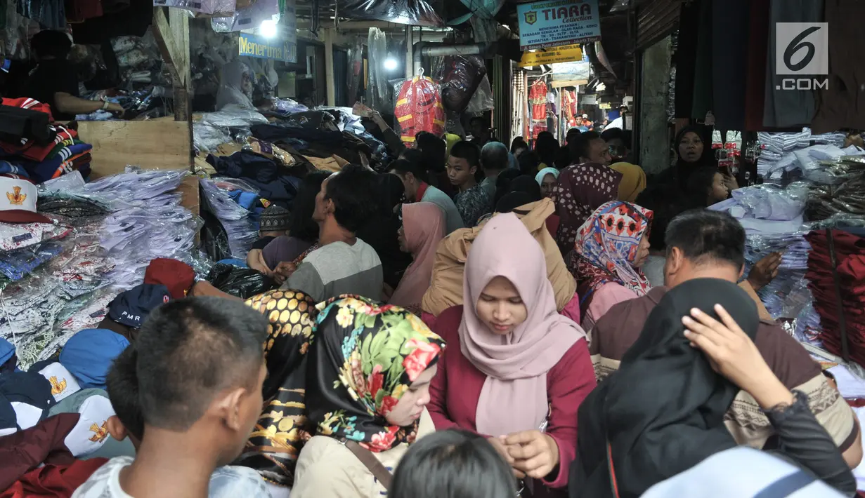Keramaian saat para para orangtua mencari seragam sekolah di Pasar Jatinegara, Jakarta, Minggu (14/7/2019). Jelang tahun ajaran baru, Pasar Jatinegara ramai didatangi para orangtua yang mencari seragam sekolah untuk anaknya. (merdeka.com/Iqbal Nugroho)