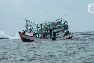 Kapal nelayan melintas di pesisir laut Jakarta, Kamis (9/1/2020). Pemprov DKI Jakarta melalui Dinas Sumber Daya Air (SDA) memetakan kawasan yang rawan diterjang banjir rob selama cuaca ekstrem melanda Jakarta pada 9 hingga 12 Januari 2020. (merdeka.com/Imam Buhori)