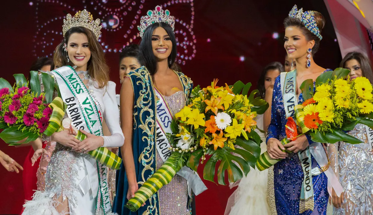 Kontestan asal Delta Amacuro, Sthefany Gutierrez (tengah) memegang bunga dan mengenakan mahkota saat dinobatkan sebagai Miss Venezuela 2017 di Caracas, Venezuela (9/11). (AFP Phot/STR)