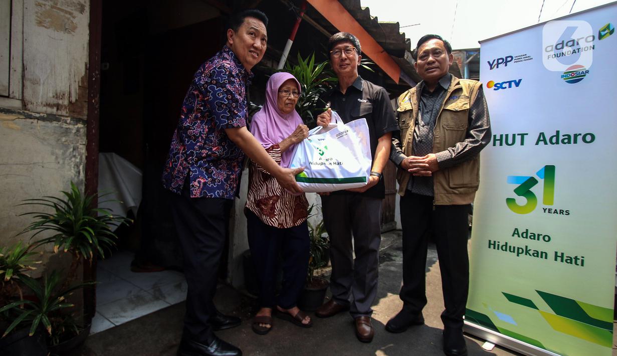 Dirut PT Surya Citra Media Tbk Sutanto Hartono, Ketua Umum Yayasan Pundi Amal Peduli Kasih Imam Sudjarwo dan Presdir PT Adaro Energy Indonesia Tbk Garibaldi Thohir saat membagikan sembako langsung kepada warga di Kampung Bali RW 05, Kebon Jeruk, Jakarta, Rabu (4/10/2023). PT Adaro Energi Tbk bersama Yayasan Pundi Amal Peduli Kasih (YPP) SCTV dan Indosiar menggelar kegiatan penyerahan sembako dalam rangka Hari Ulang Tahun (HUT) Adaro ke-31 dengan tema “Adaro Hidupkan Hati”. (Liputan6.com/Angga Yuniar)
