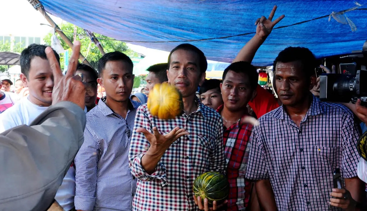Di pasar Kebayoran Lama, Jokowi yang mengenakan kemeja kotak-kotak mengunjungi lapak pedagang buah blewah, Jakarta, Senin (30/6/14). (Liputan6.com/Andrian M Tunay)